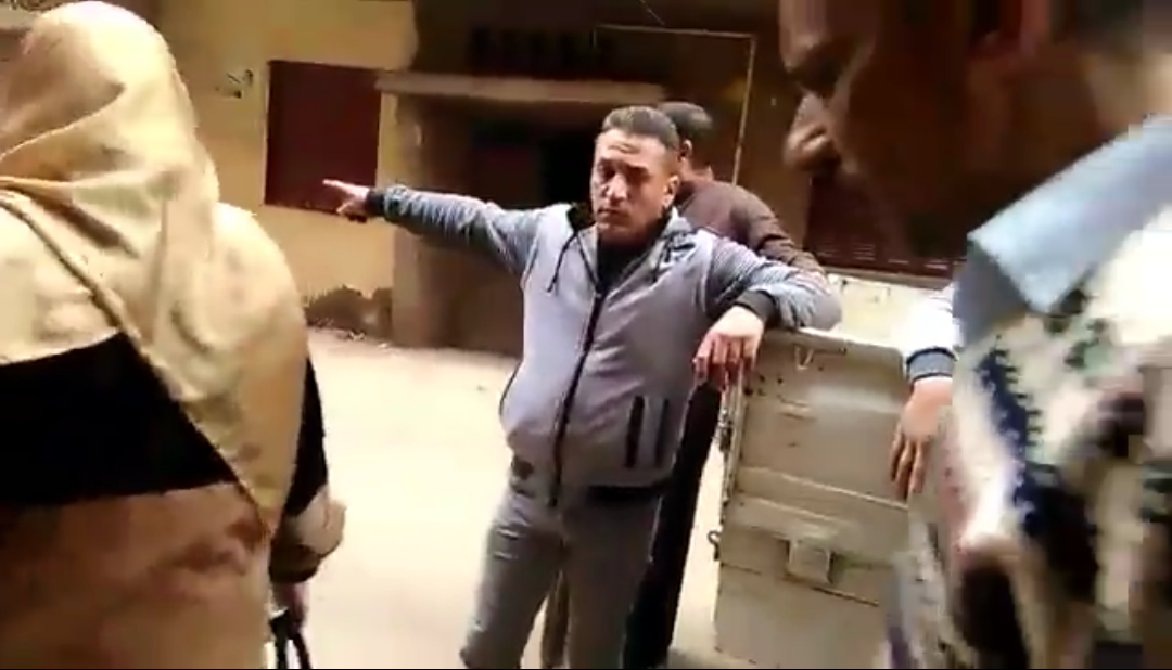 موظف الحي يشير بيدة لموظف الطب البيطري لوضع السم للكلاب